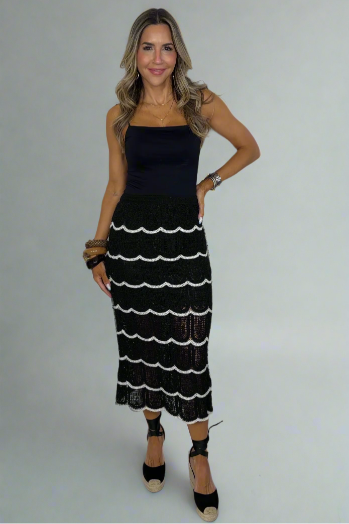 Woman wearing a black and white dress against a white background