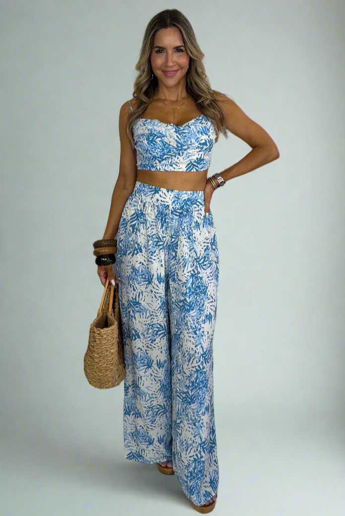 Woman wearing a blue floral outfit against a white background
