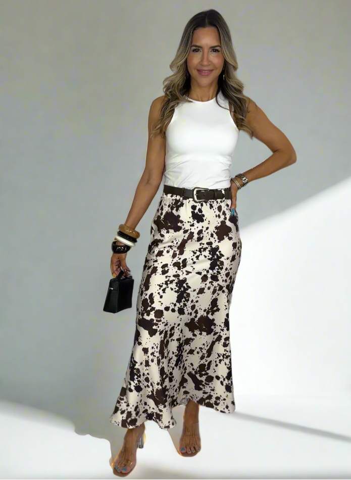 Woman wearing a white top and patterned skirt on a white background