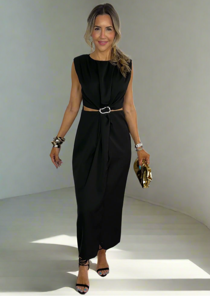 Woman in a black dress standing on a white staircase