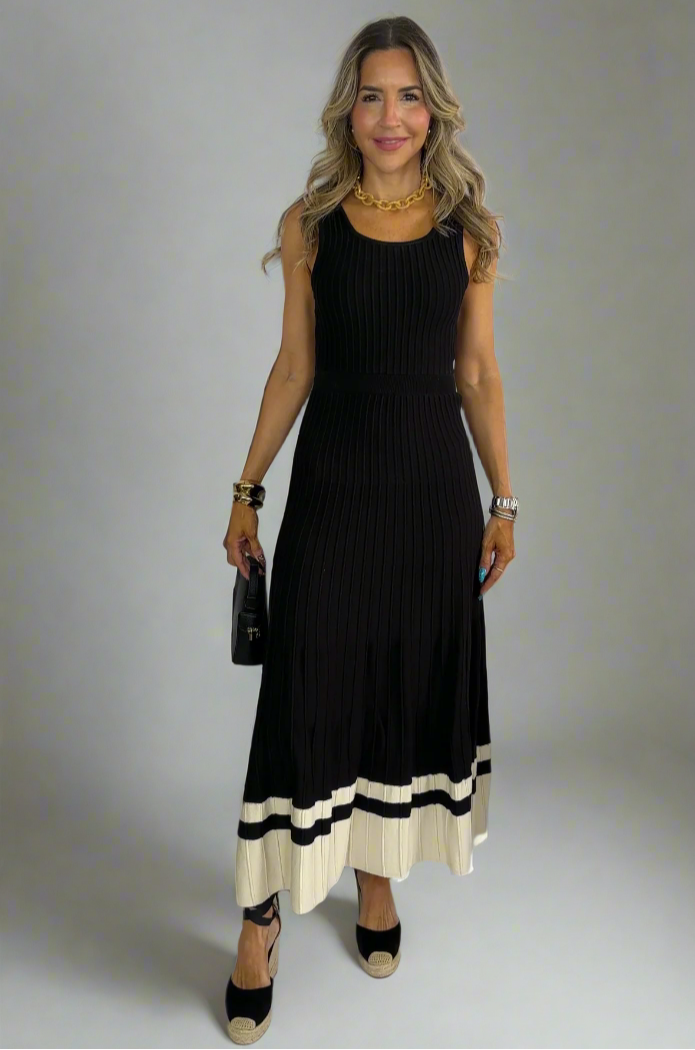 Woman wearing a black dress with a white hem against a white background