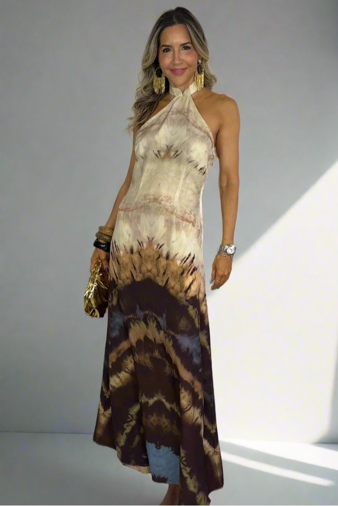 Woman wearing a tie-dye halter neck dress on a white background