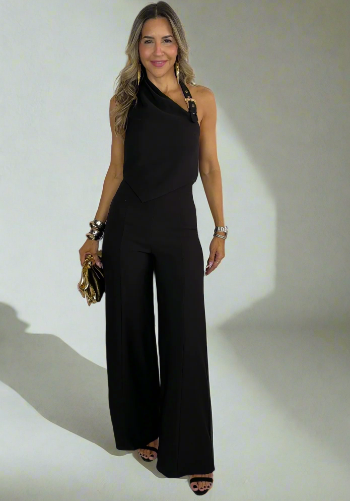 Woman wearing a black jumpsuit against a white background