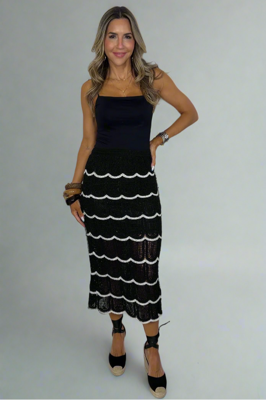 Woman wearing a black and white dress against a white background