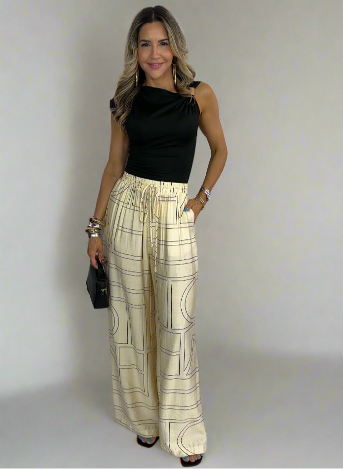 Woman wearing a black top and plaid pants against a white background