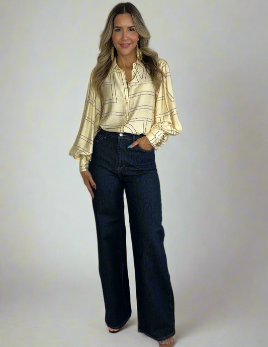 Woman wearing a yellow blouse and dark blue pants on a white background