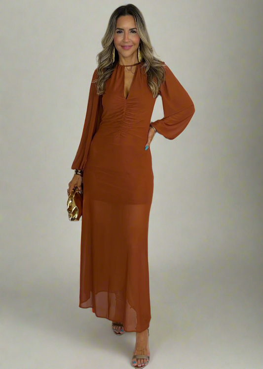 Woman wearing a rust-colored dress against a white background
