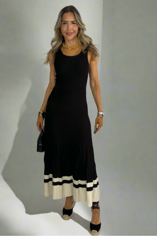 Woman wearing a black dress with white accents against a white background