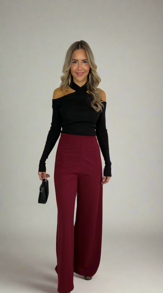Woman wearing a black top and red pants on a white background
