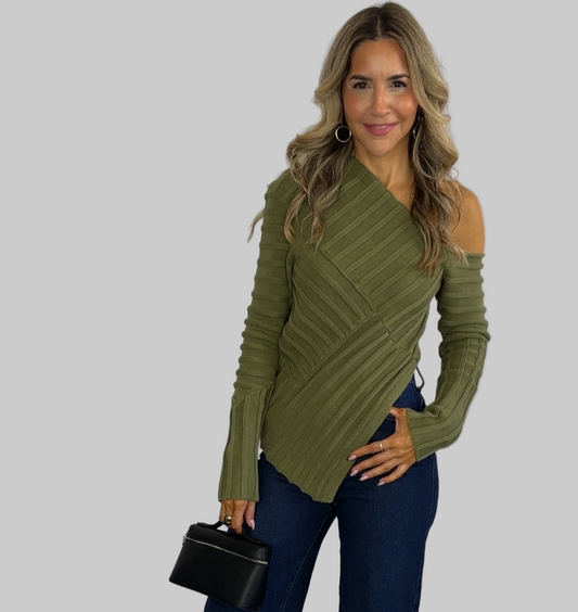 Woman in green top and blue pants posing against a white background